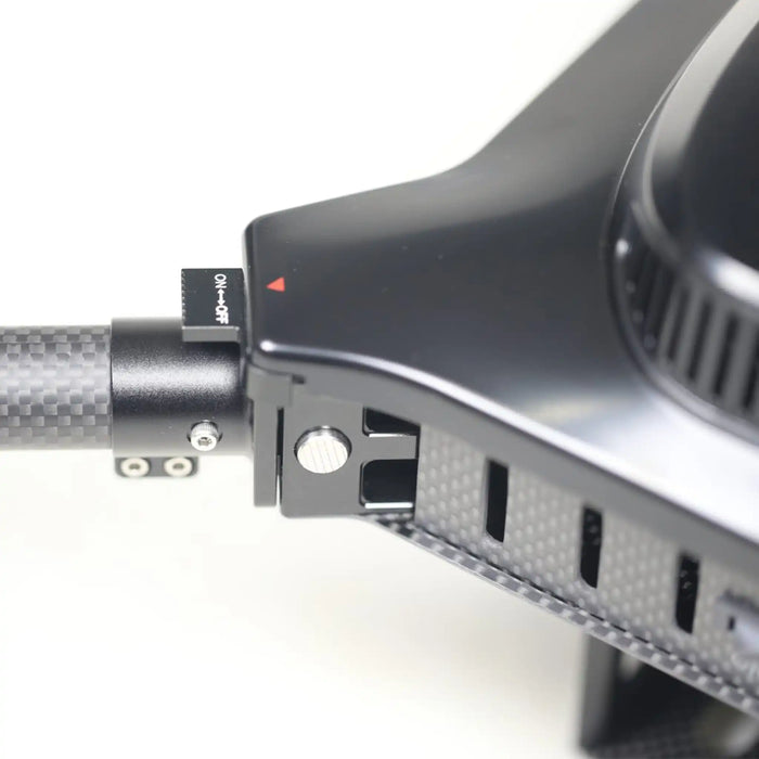 Close-up detail of a black and carbon-fiber accessory with a small switch labeled ON-OFF and a red indicator mark, shown against a white background.