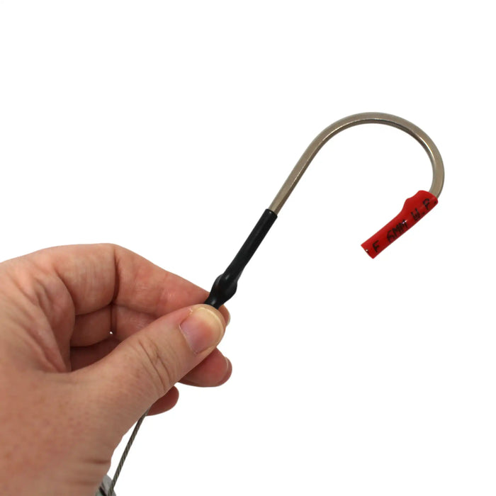 Fishing hook with red treble hooks held by a hand on a white background