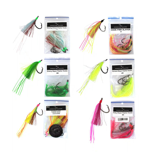 Six packaged fishing lures arranged in a 3-by-2 grid on a white background, each shown with its clear plastic bag and hook. The lures are in bright neon colors including pink, green, yellow, orange, and red, with some featuring glittery or metallic finishes.