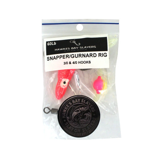 A packaged fishing rig labeled 'Hawkes Bay Slayers Snapper/Gurnard Rig' in a clear plastic bag with a printed header card. The rig includes a red and white lure, a bright pink and yellow bead, metal eye hooks, and a black circular branded weight or weighter.